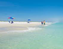 White sand shoreline with beach umbrellas on emerald water